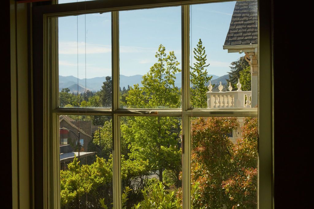 A window with a view of trees and mountains