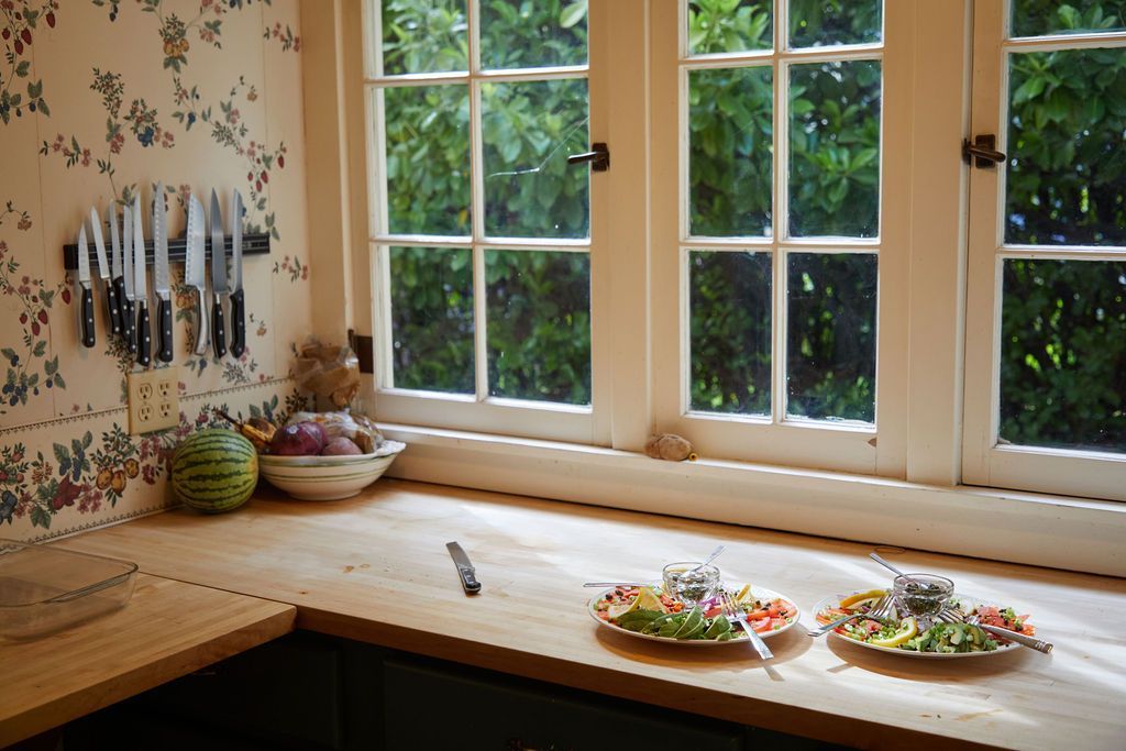A kitchen counter with plates of food and knives on it