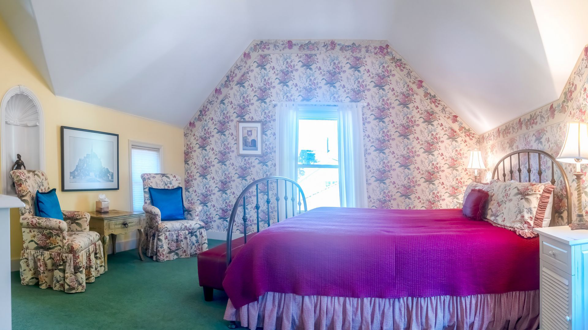 A bedroom with a bed , chairs , and a window.