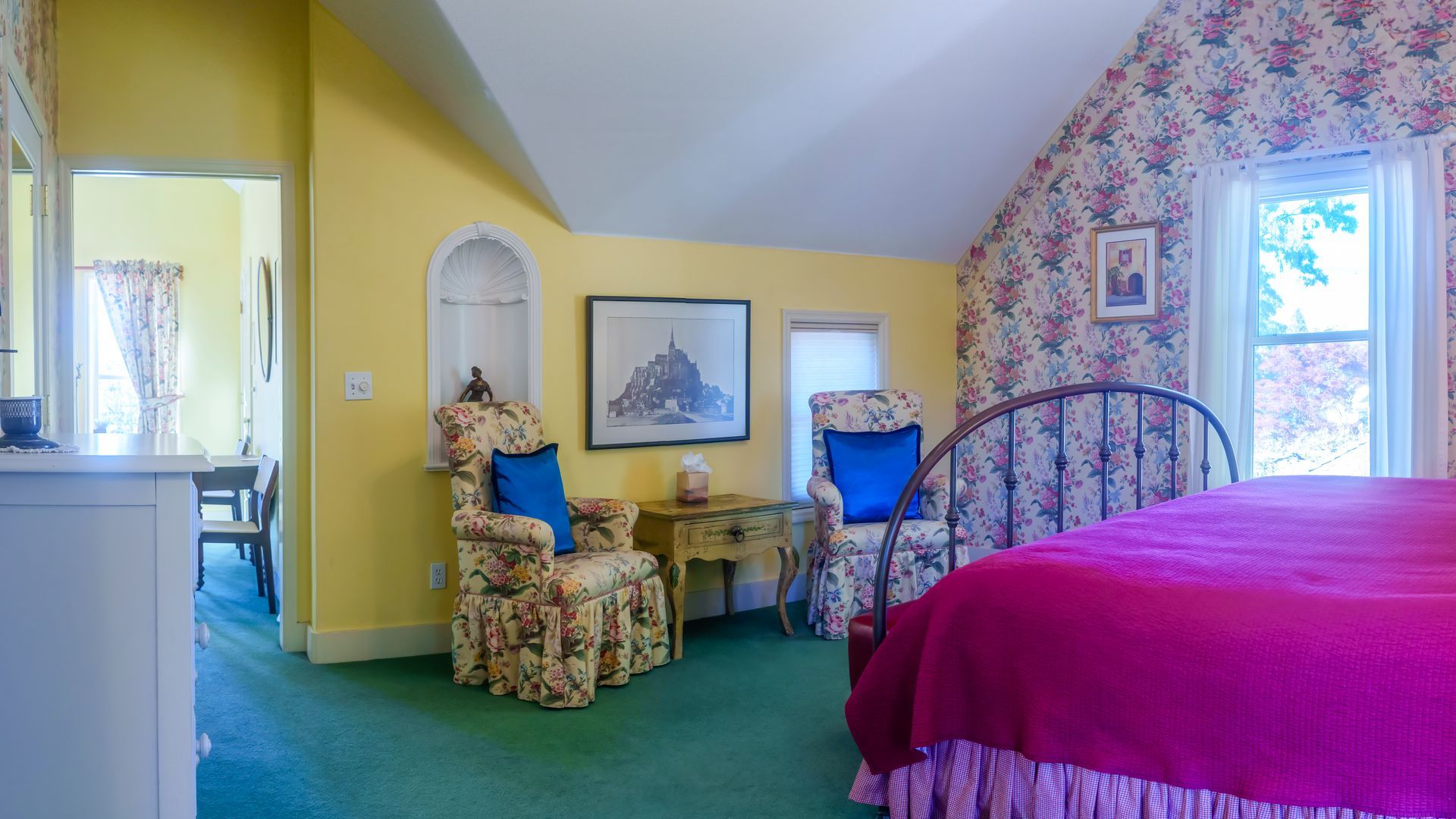 A bedroom with yellow walls and a pink bed