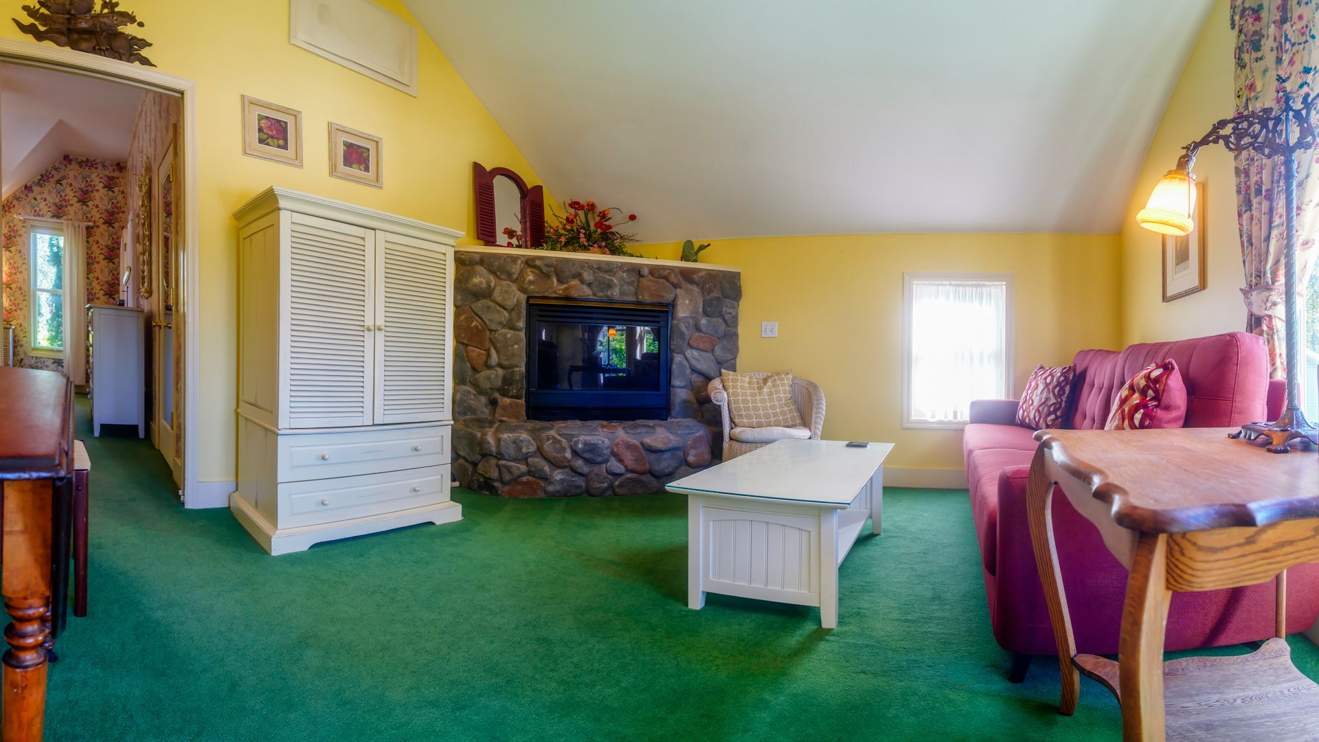 A living room with a fireplace , couch , table and chairs