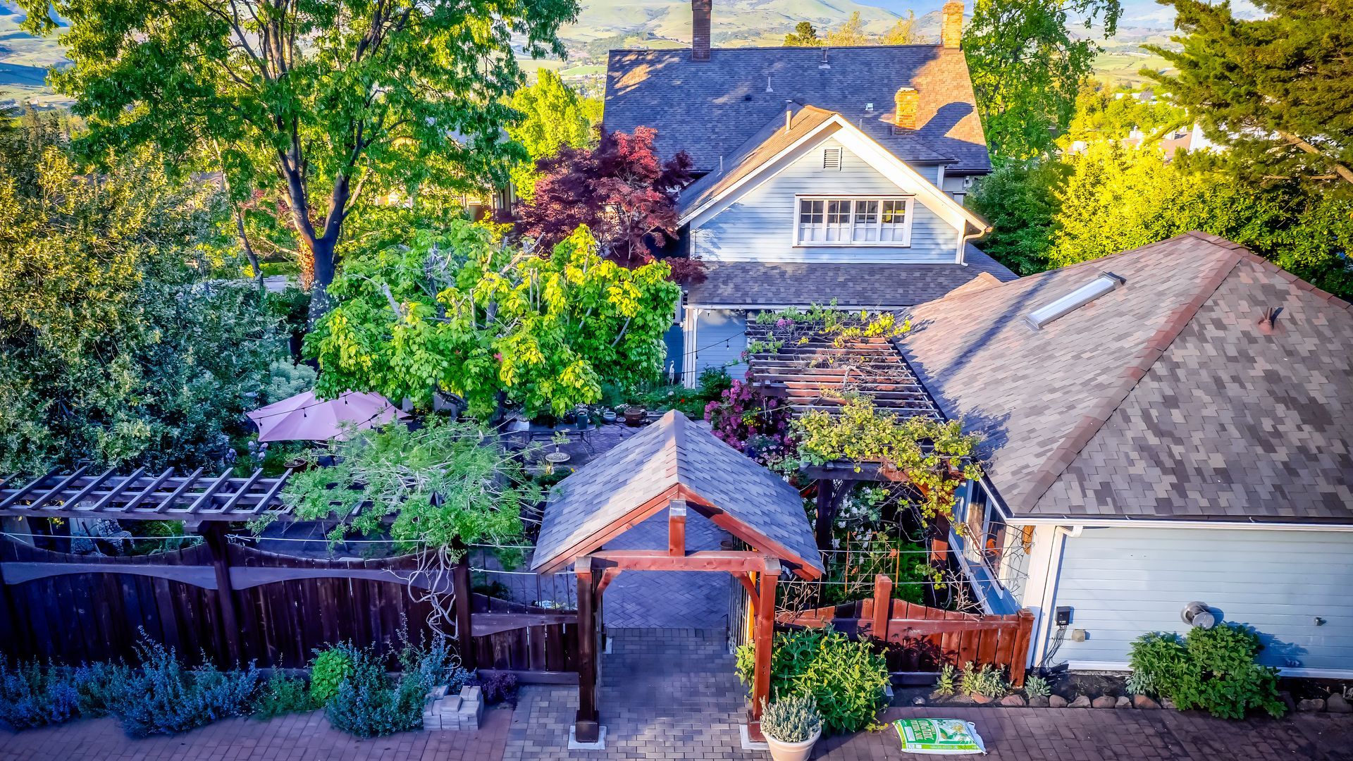 An aerial view of a large house surrounded by trees and bushes.