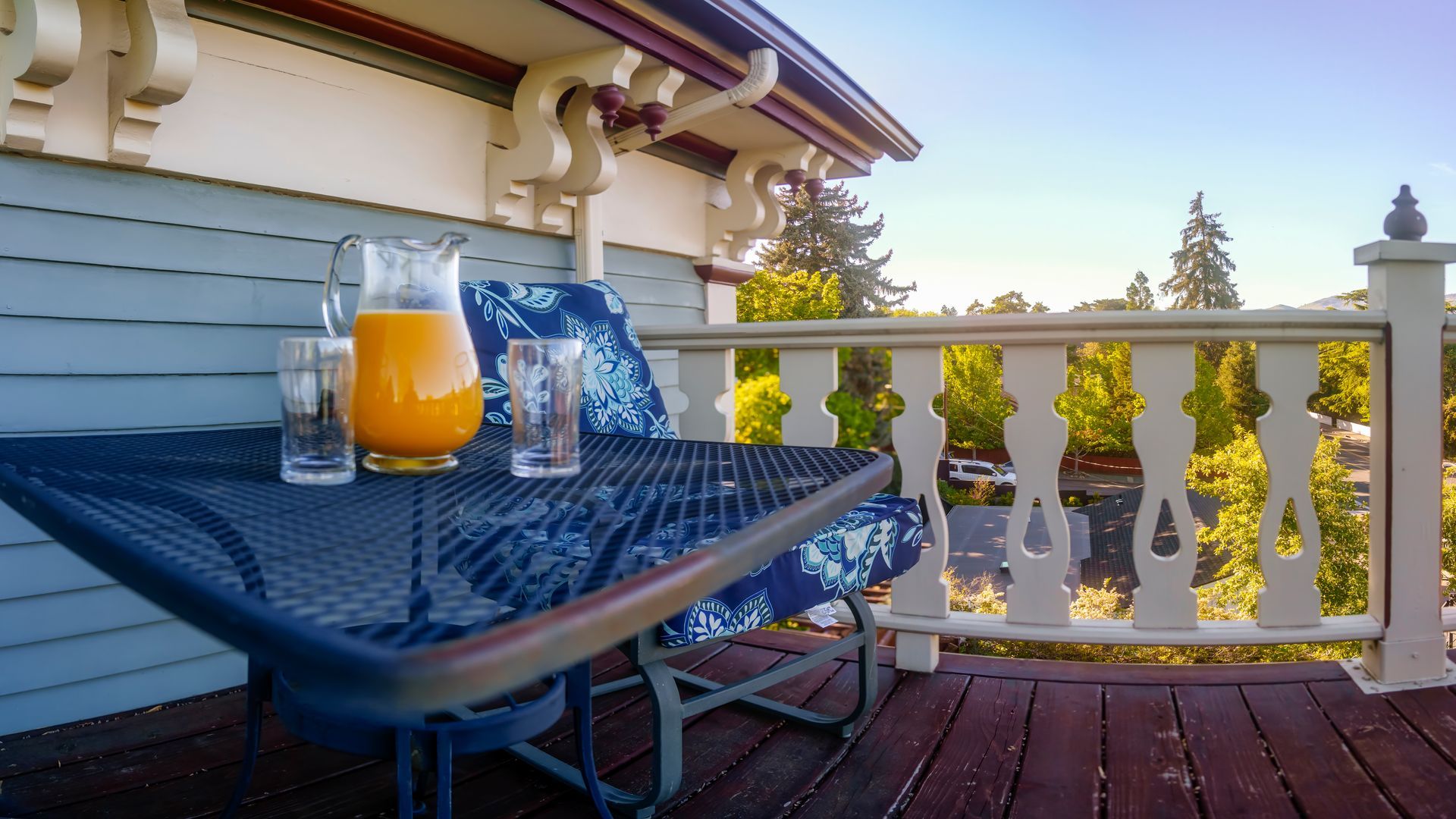 A table with a pitcher of orange juice and two glasses on it