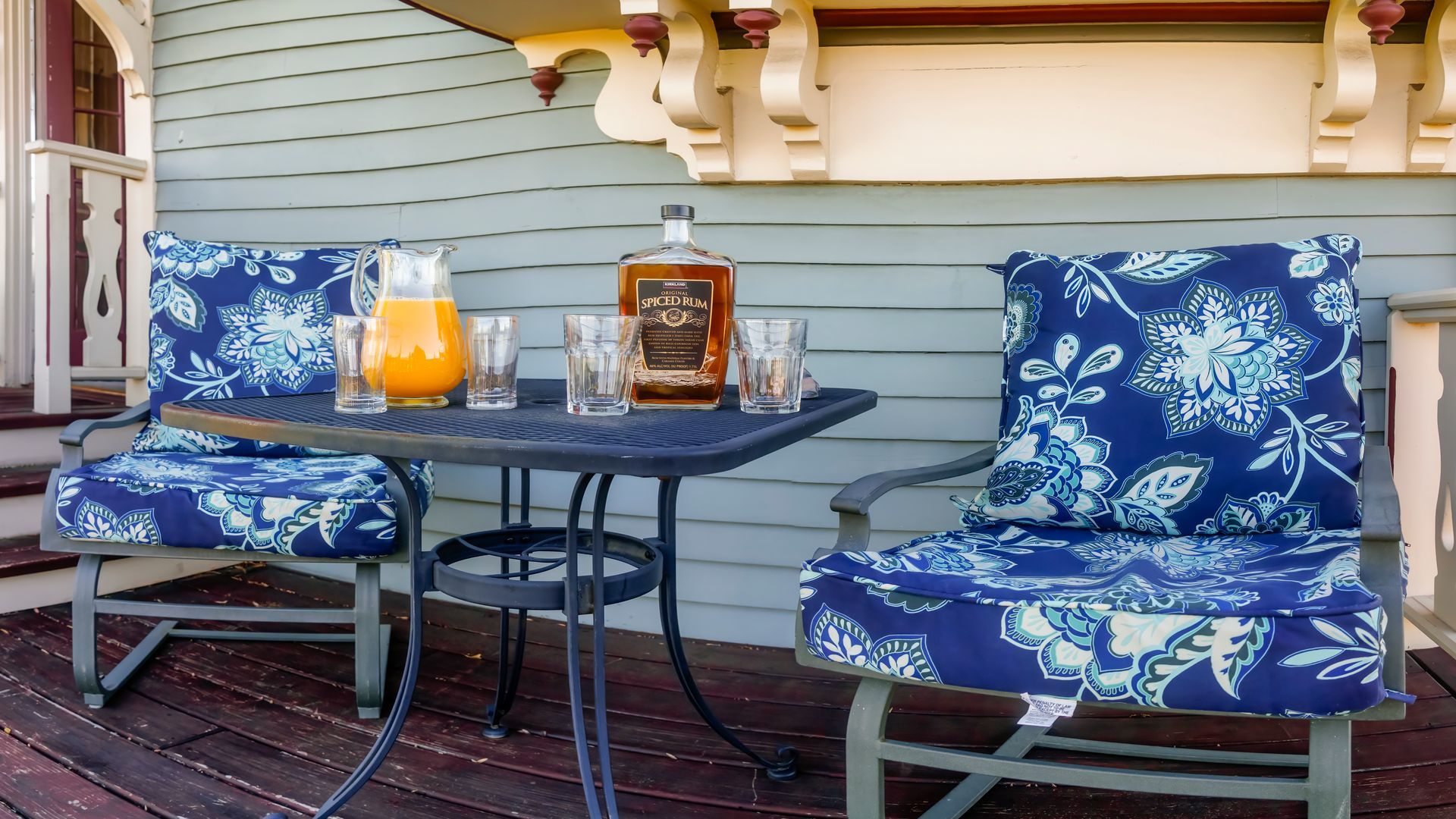 Two chairs and a table with a bottle of whiskey on it