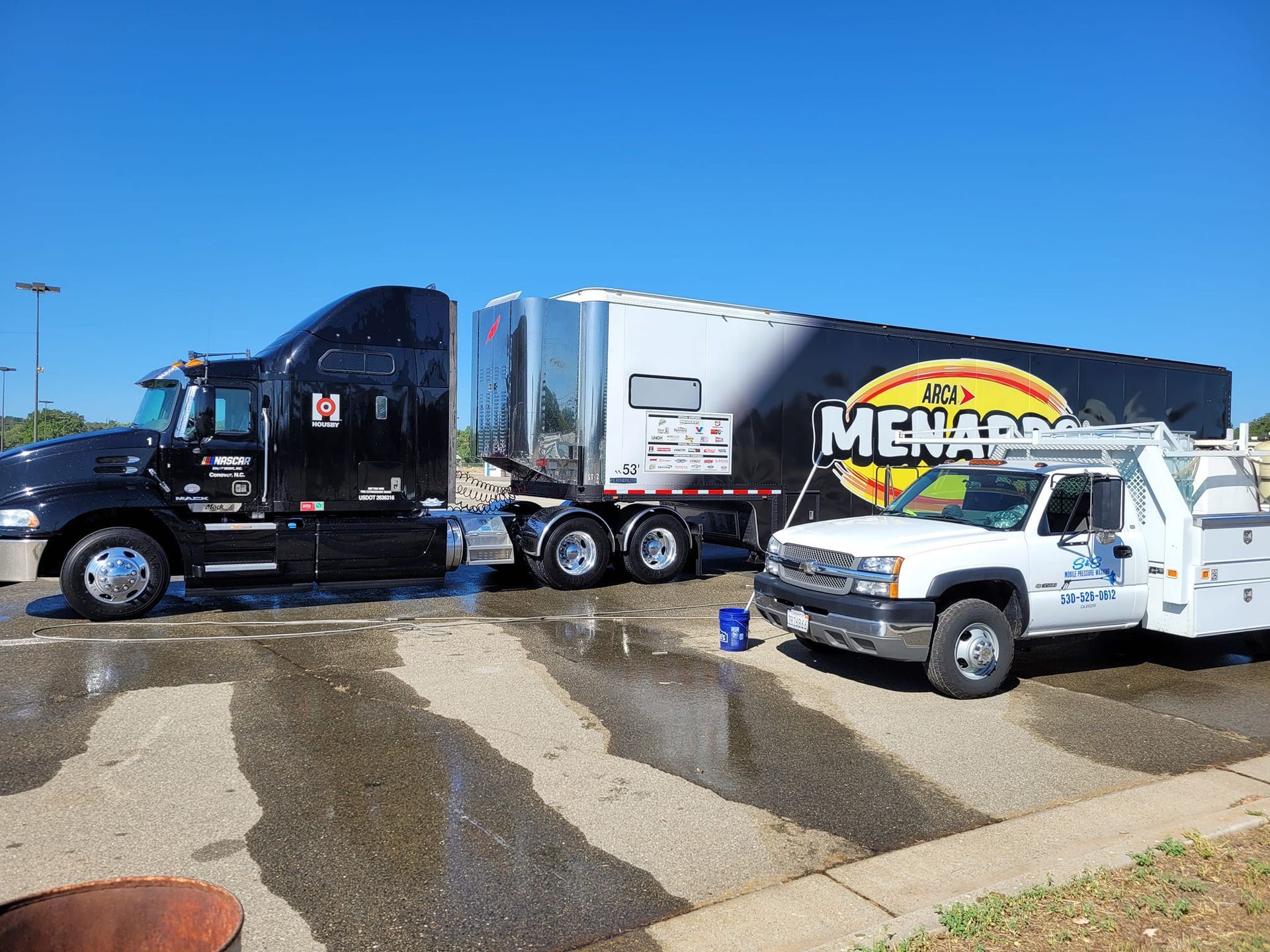 Two semi trucks are parked next to each other in a parking lot.