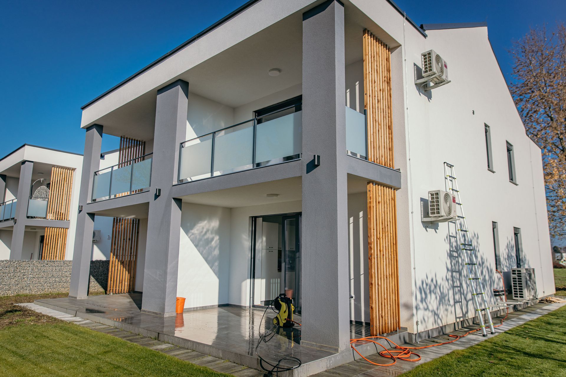 A large white house with a lot of windows and balconies is being built.