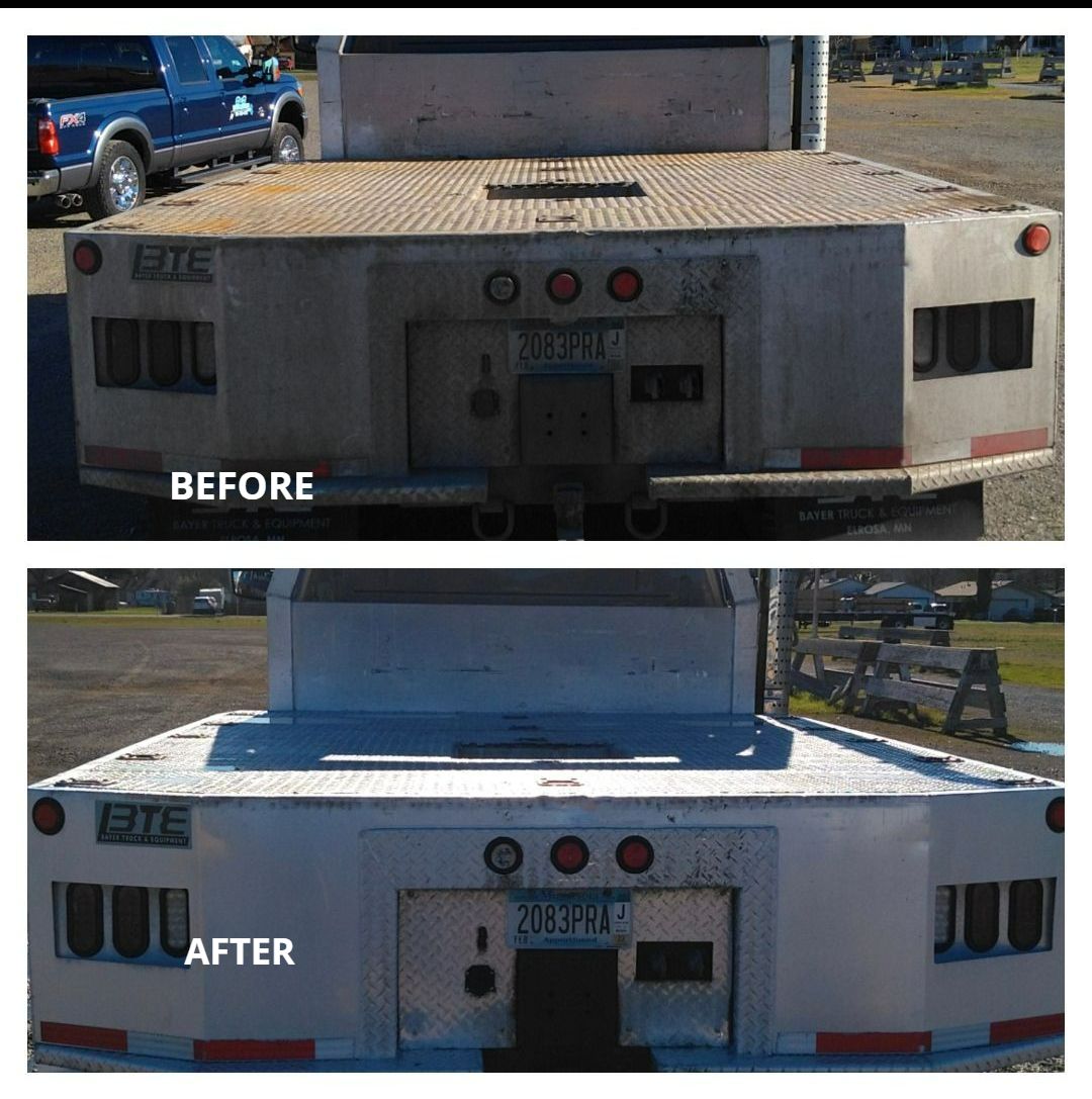 A person is using a high pressure washer to clean a wooden fence.