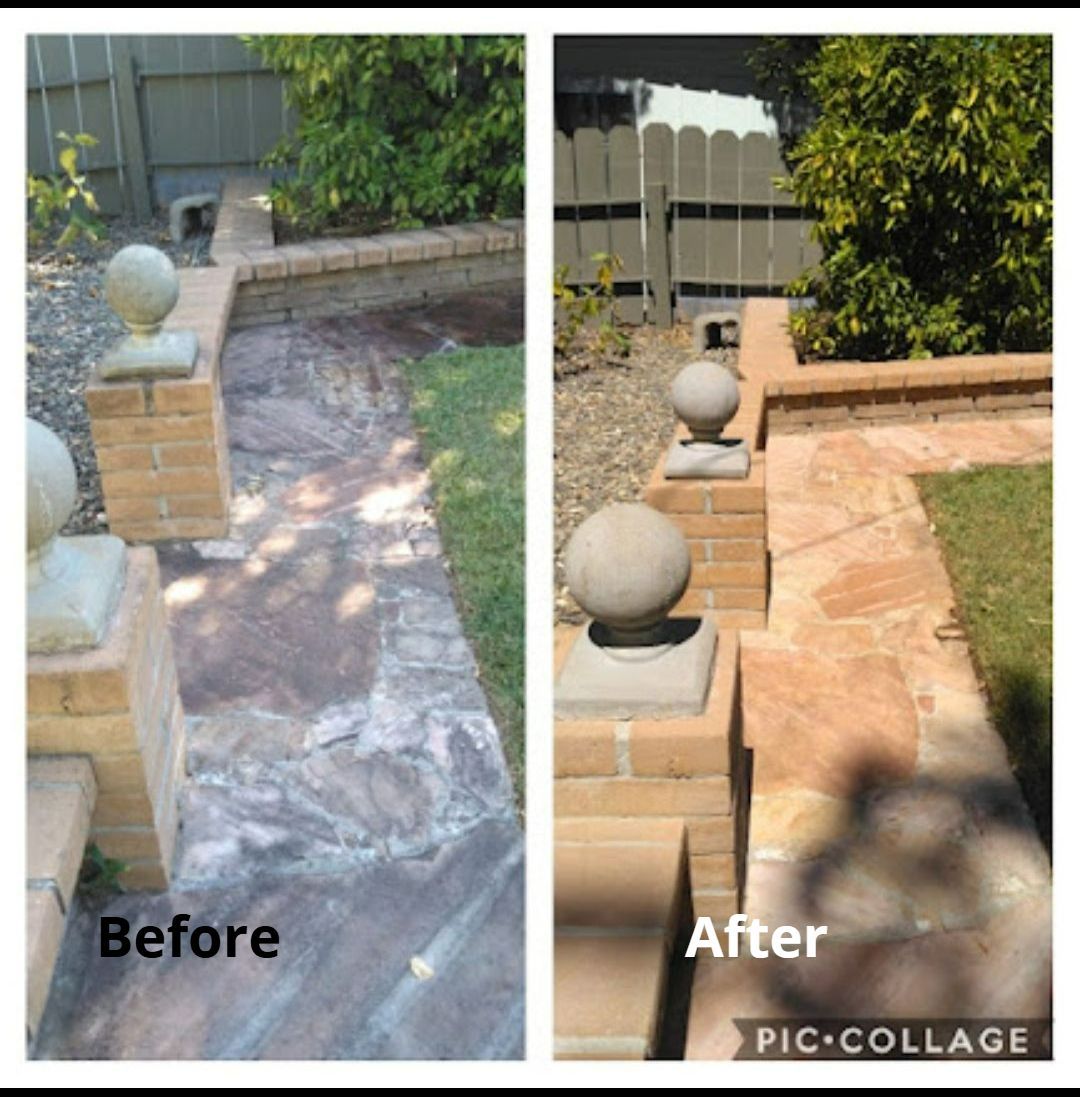 A man is using a high pressure washer to clean a sidewalk.