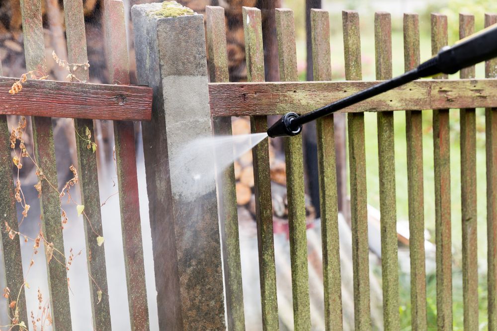 Pressure Washing a Weathered Wooden Fence Post and Planks, Spraying Water — Slash Mulch Co in Googa Creek, QLD