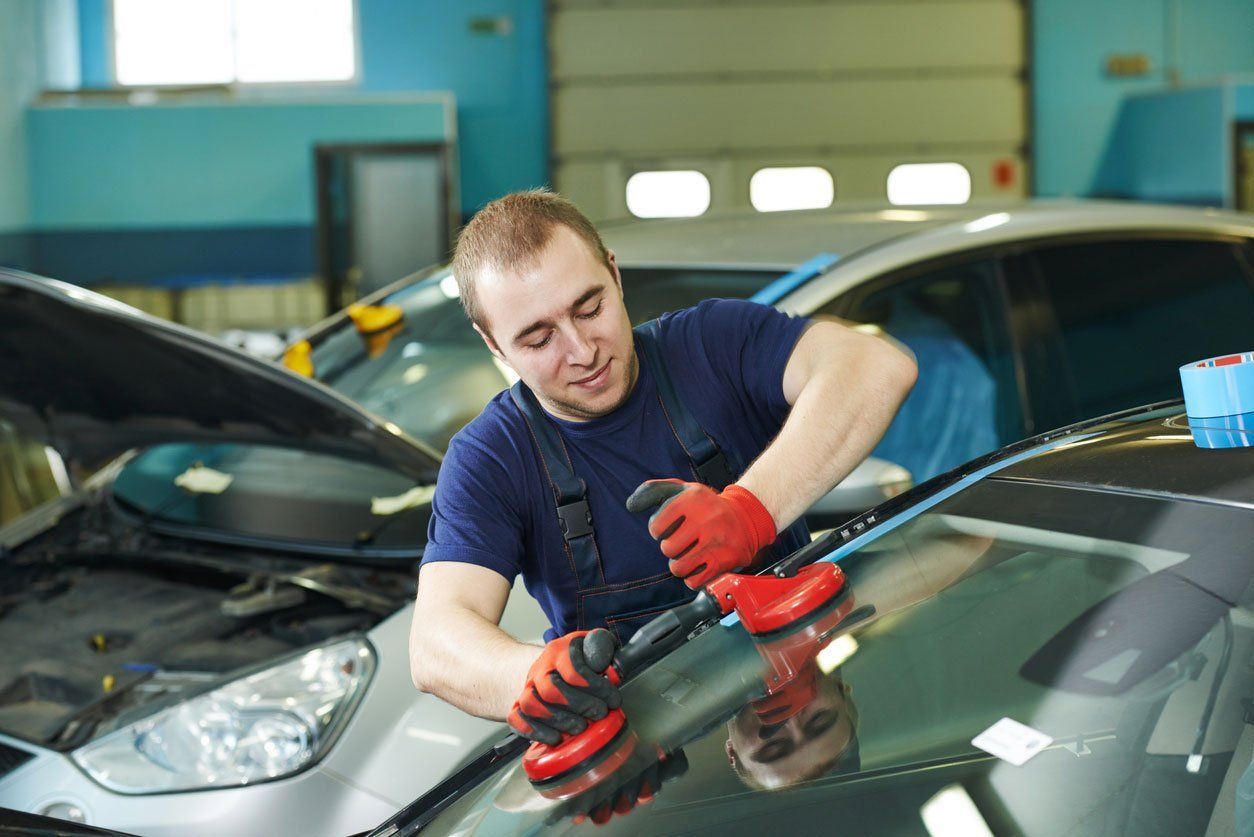 Man replacing car windshield
