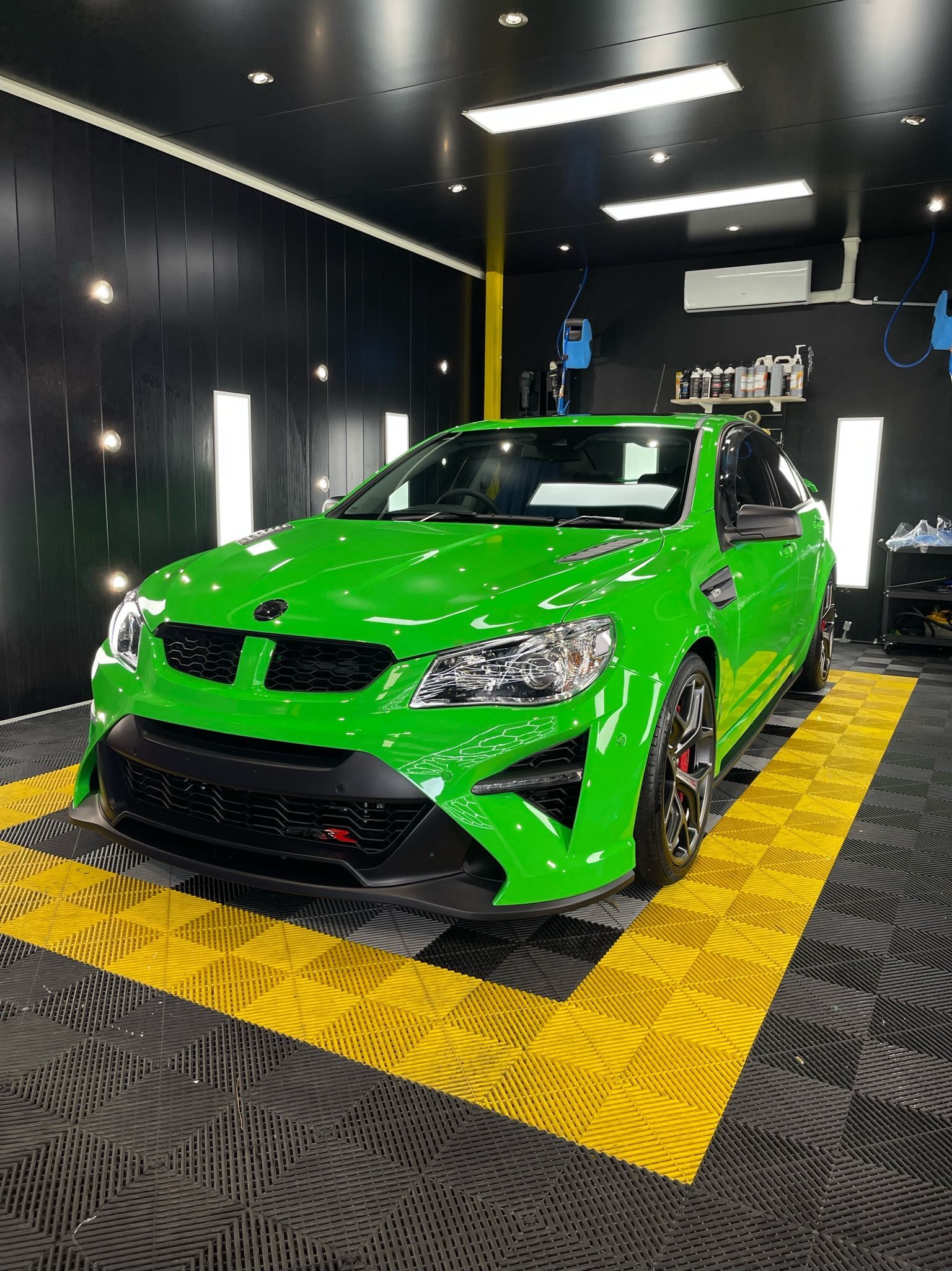 Bright green car with black accents in a garage on a yellow floor — Clarence Valley Detailing in Grafton, NSW