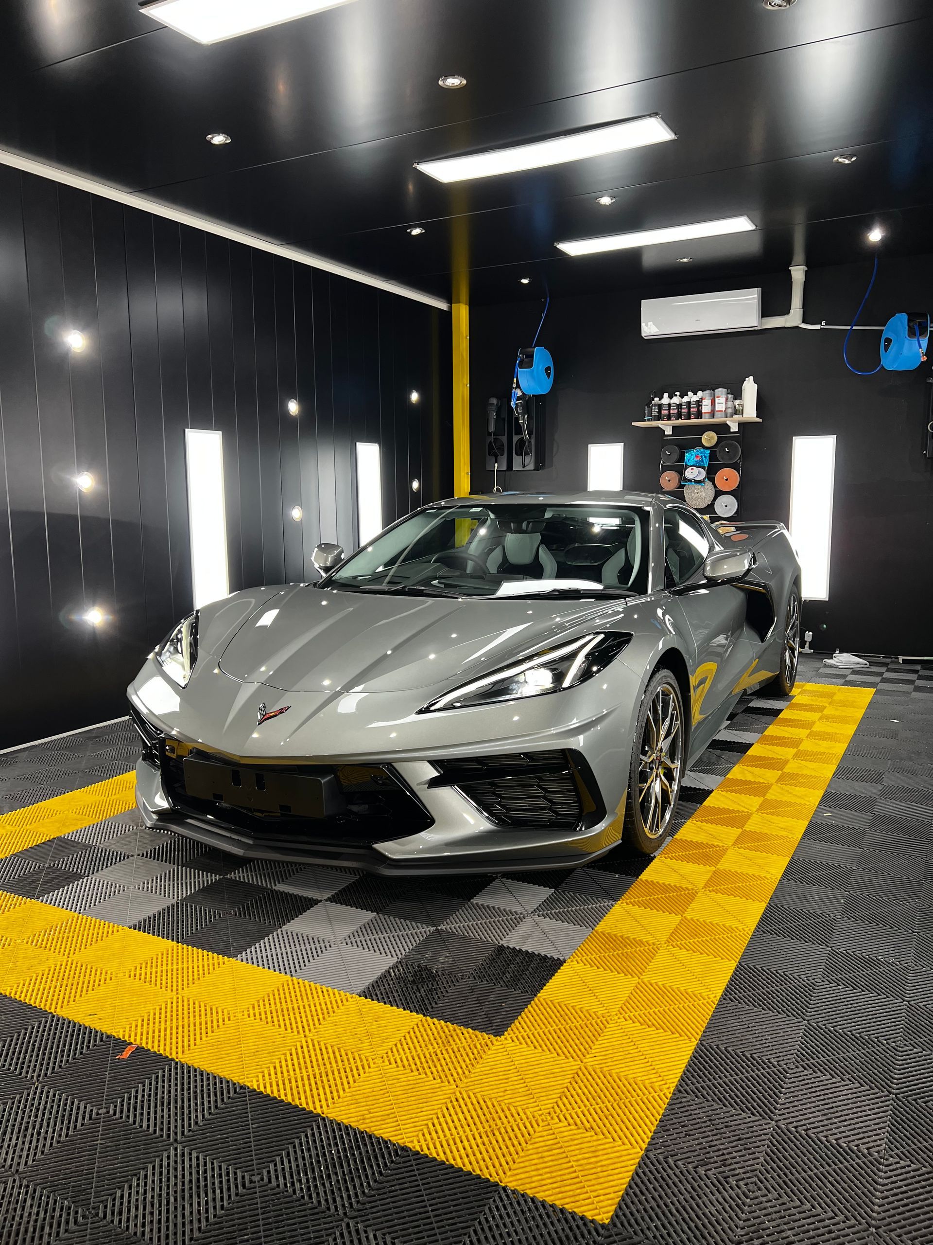 A Grey Sports Car Parked On A Checkered Floor In A Garage — Clarence Valley Detailing In Yamba, NSW