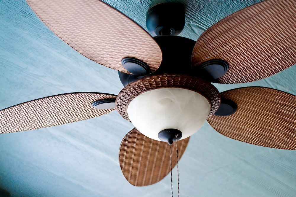 A Ceiling Fan With Wicker Blades And A Light — Luke Jones Electrical In Bellambi, NSW