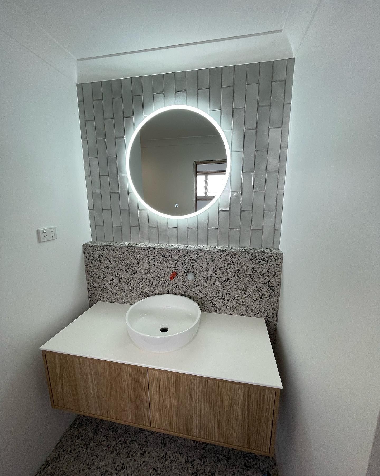 Electrician Is Using A Multimeter To Test A Light Fixture — Luke Jones Electrical In Bellambi, NSW