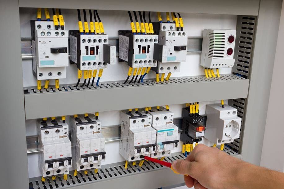 Electrician Is Holding A Circuit Breaker Box In Their Hands — Luke Jones Electrical In Bellambi, NSW
