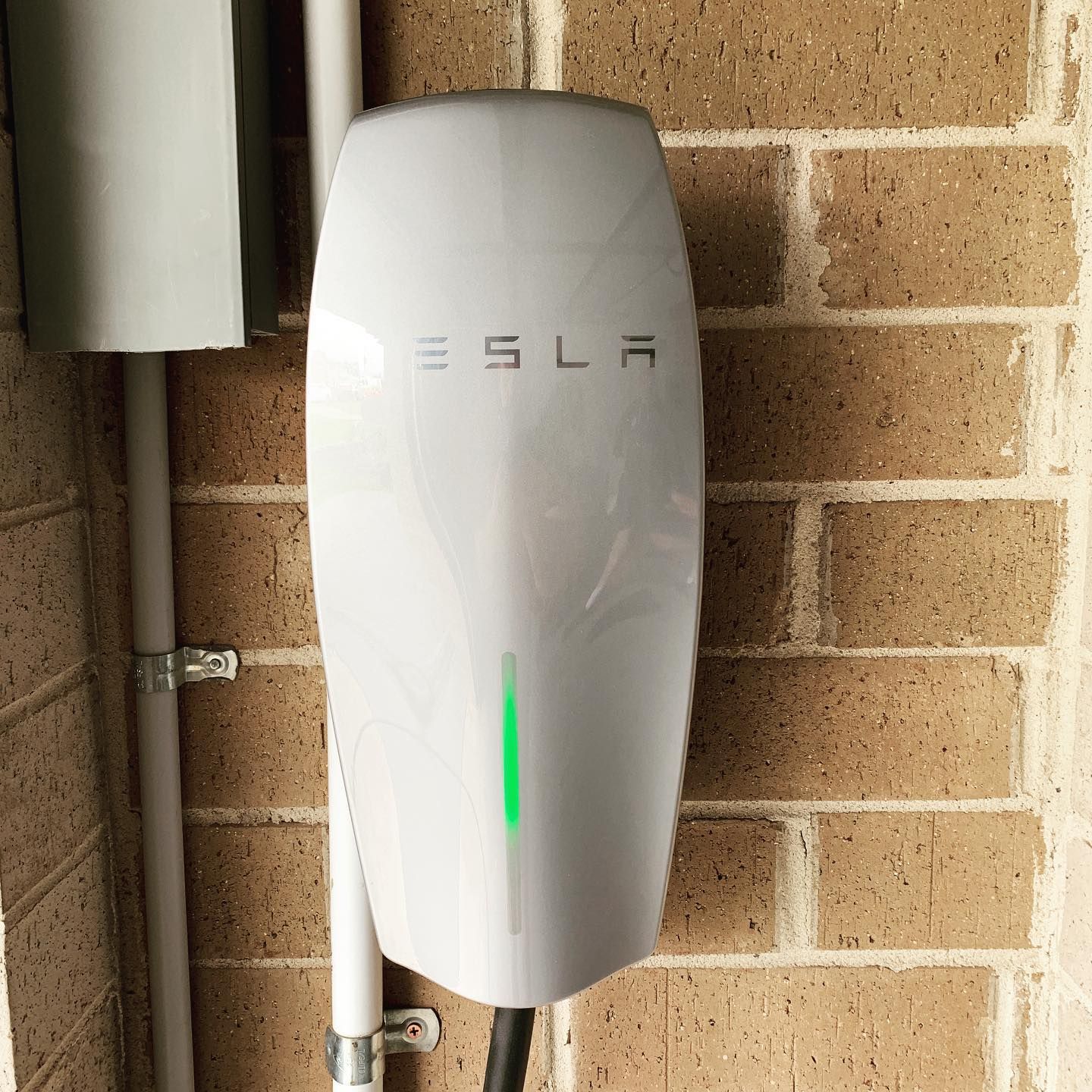 An Electric Car Is Being Charged At A Charging Station — Luke Jones Electrical In Bellambi, NSW