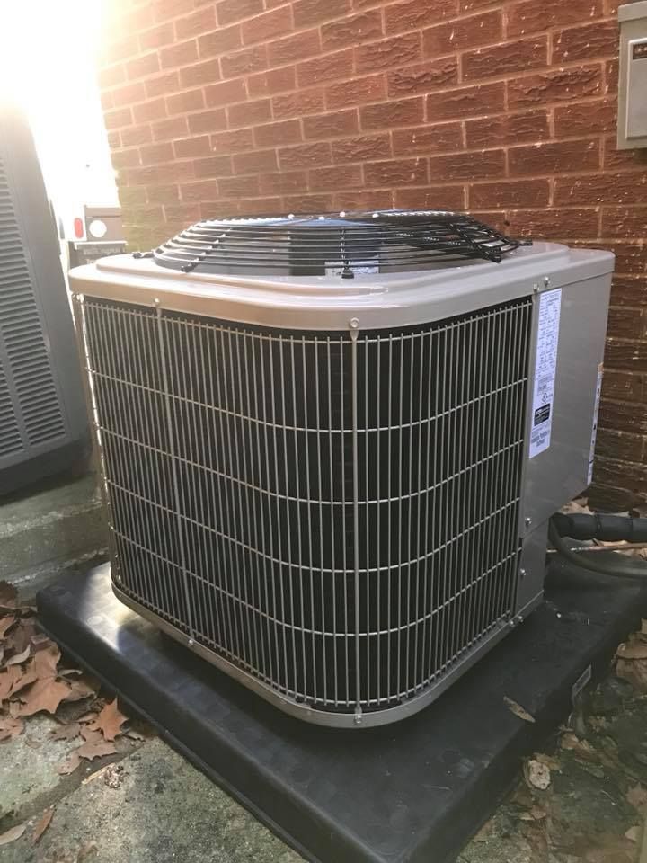 Air Connections Inc - A large air conditioner is sitting outside of a brick building.
