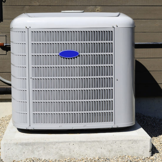 A carrier air conditioner is sitting on a concrete base