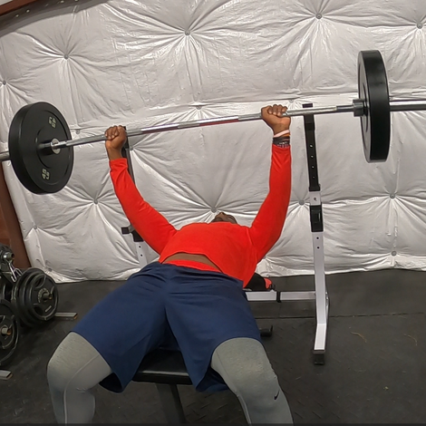 A man is laying on a bench lifting a barbell - Odenton , MD - Fitness Forever