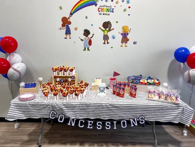Concessions table with food, baseball balloons, and a 