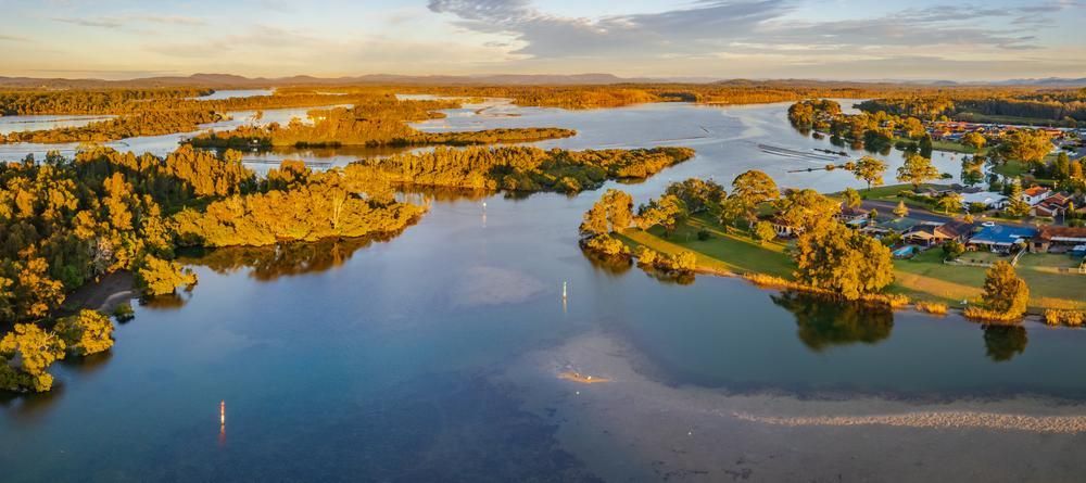An Aerial View Of A Large Lake Surrounded By Trees And Houses — Southern Bricks & Pavers In Moruya, NSW