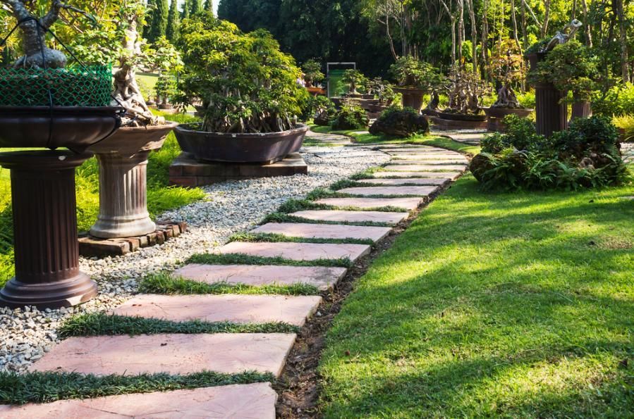 A Stone Walkway In A Park Surrounded By Grass And Trees — Southern Bricks & Pavers In Batemans Bay, NSW