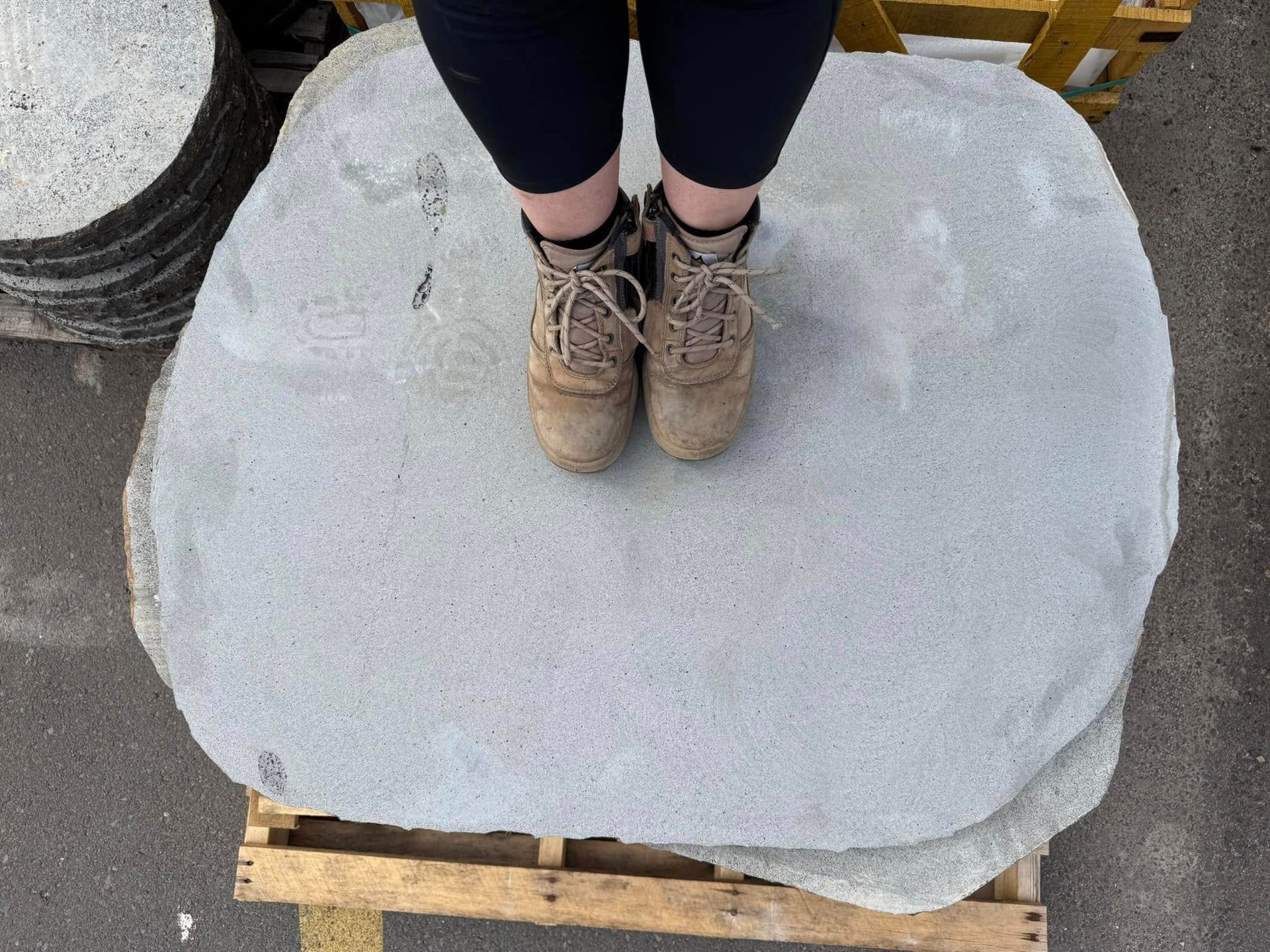A Person is Standing on Top of a Pile of Rocks on a Wooden Pallet — Southern Bricks & Pavers In Ulladulla, NSW