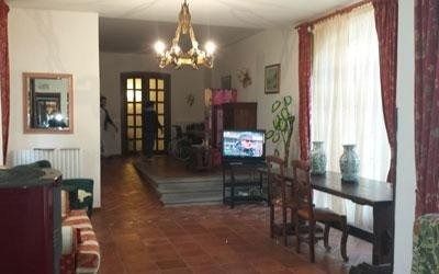 Una persona in camice medico sorride calorosamente mentre tocca delicatamente il braccio di una persona anziana durante una conversazione.