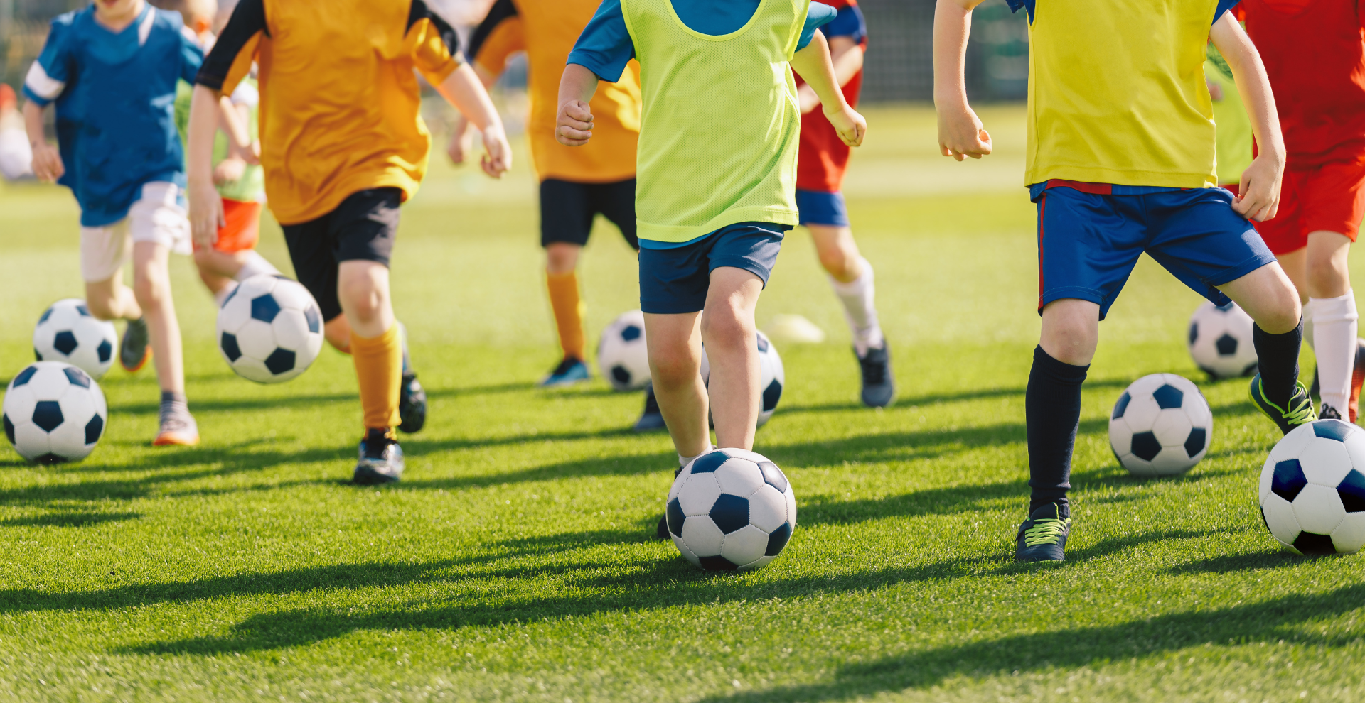Een groep jonge jongens speelt voetbal op een veld.
