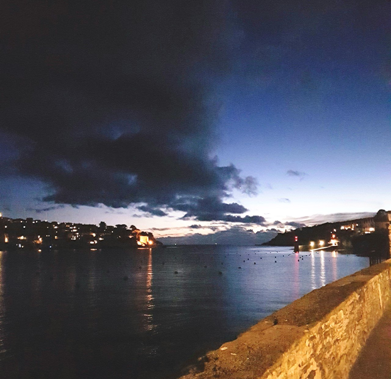 Fowey Harbour with reflected light on the water and an early night sky