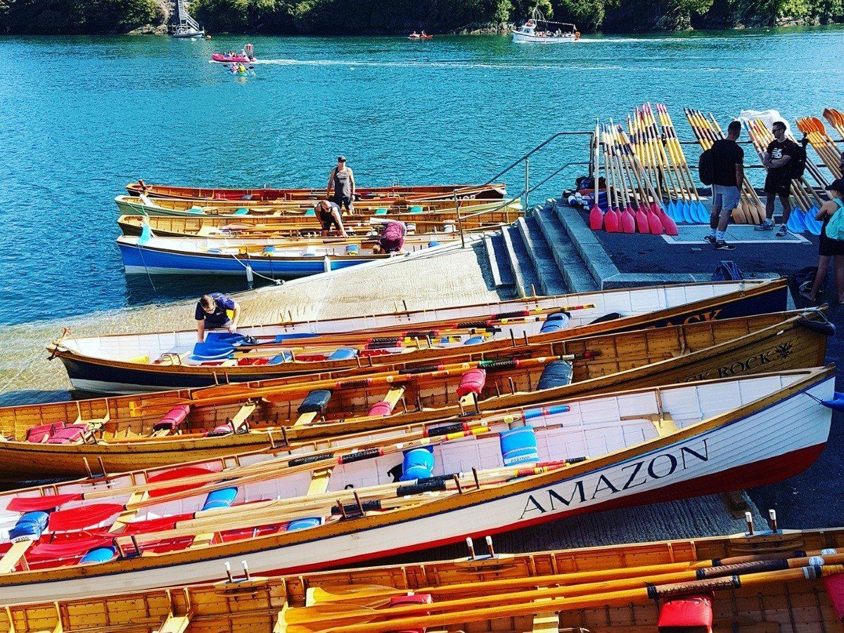 Colourful Cornish gig rowing boats drawn up on a slipway before a Regatta race