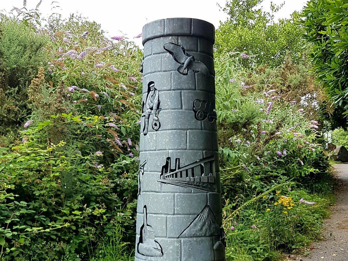 Chimney sculpture featuring depictions of Cornish mining heritage