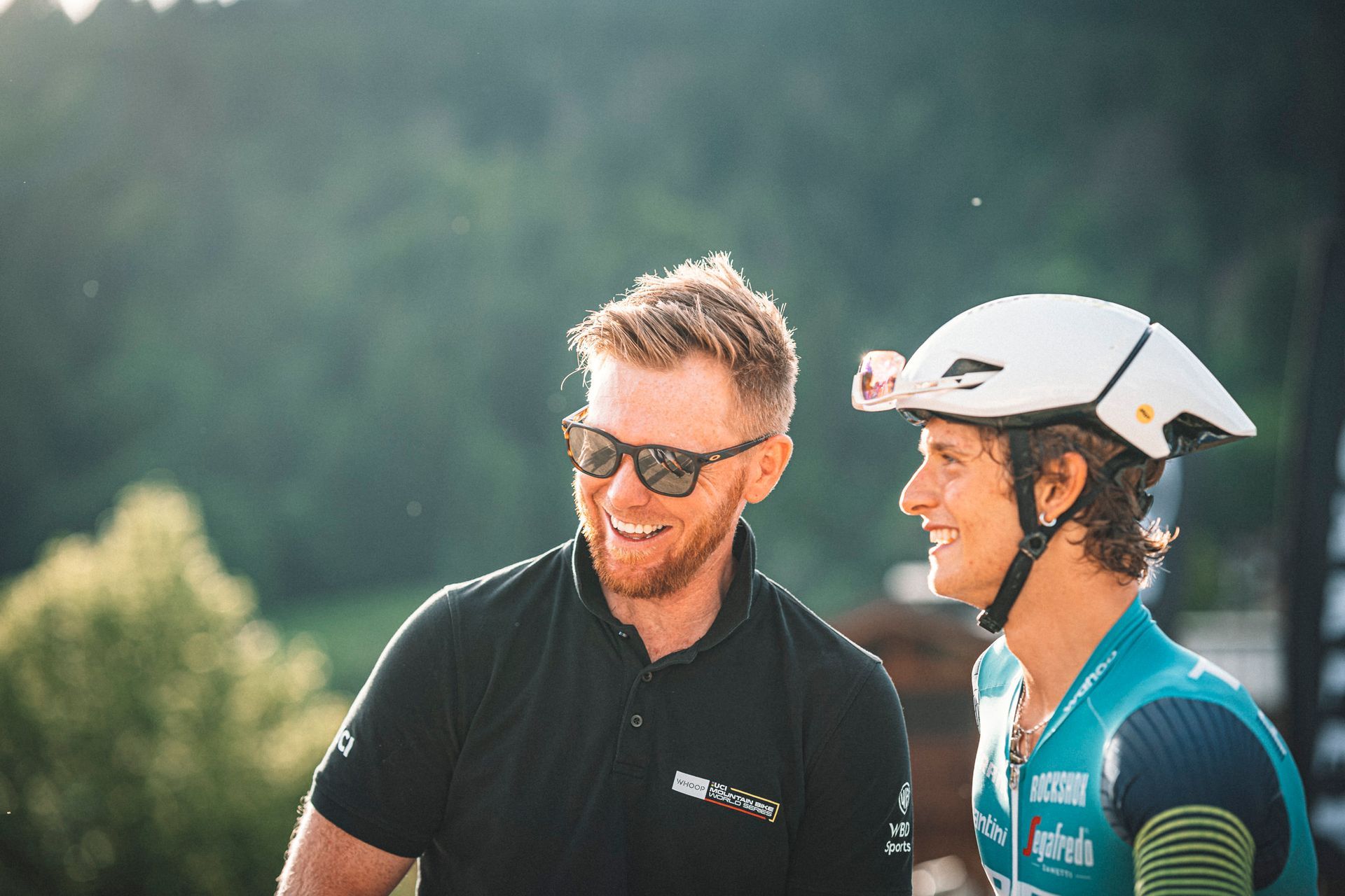 A man is holding a microphone and talking to a bicycle racer.