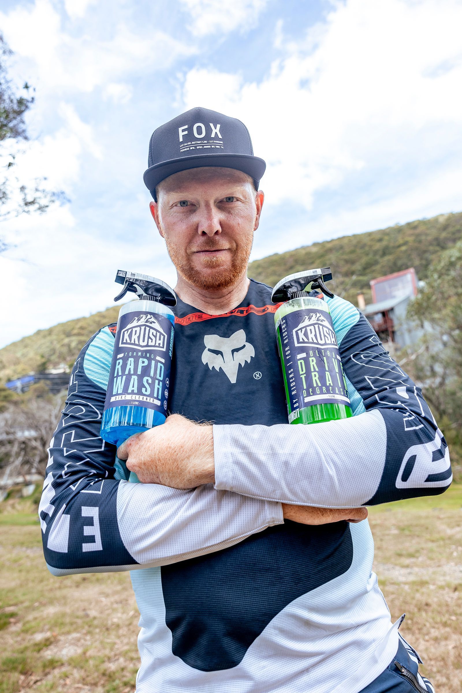 A man with a beard is smiling in a black and white photo.
