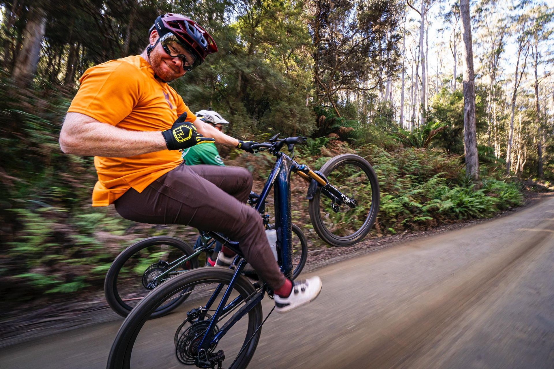 A man is riding a bike down a dirt road.