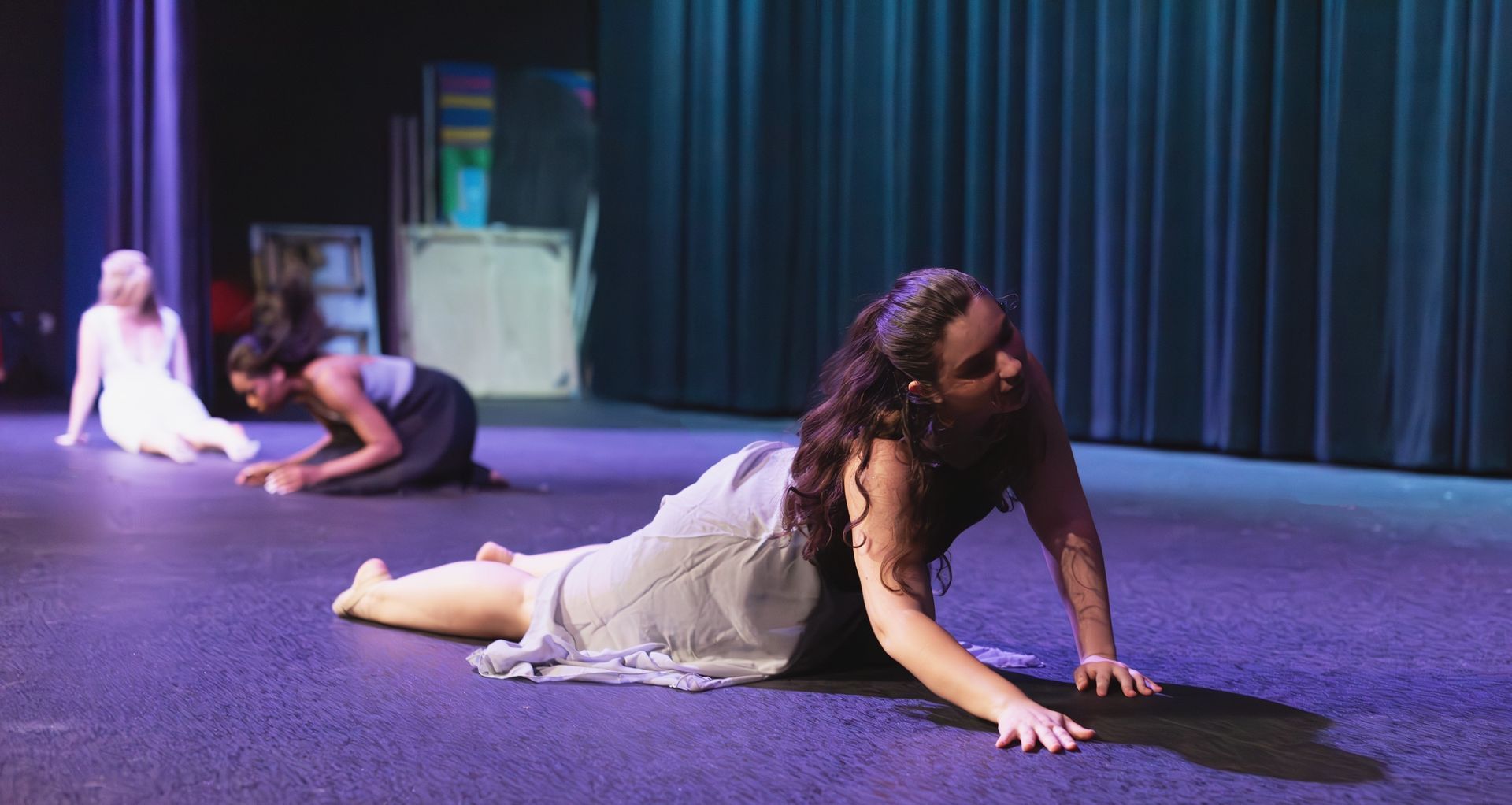 a single dancer at the height of a stag leap against a bluish purple light