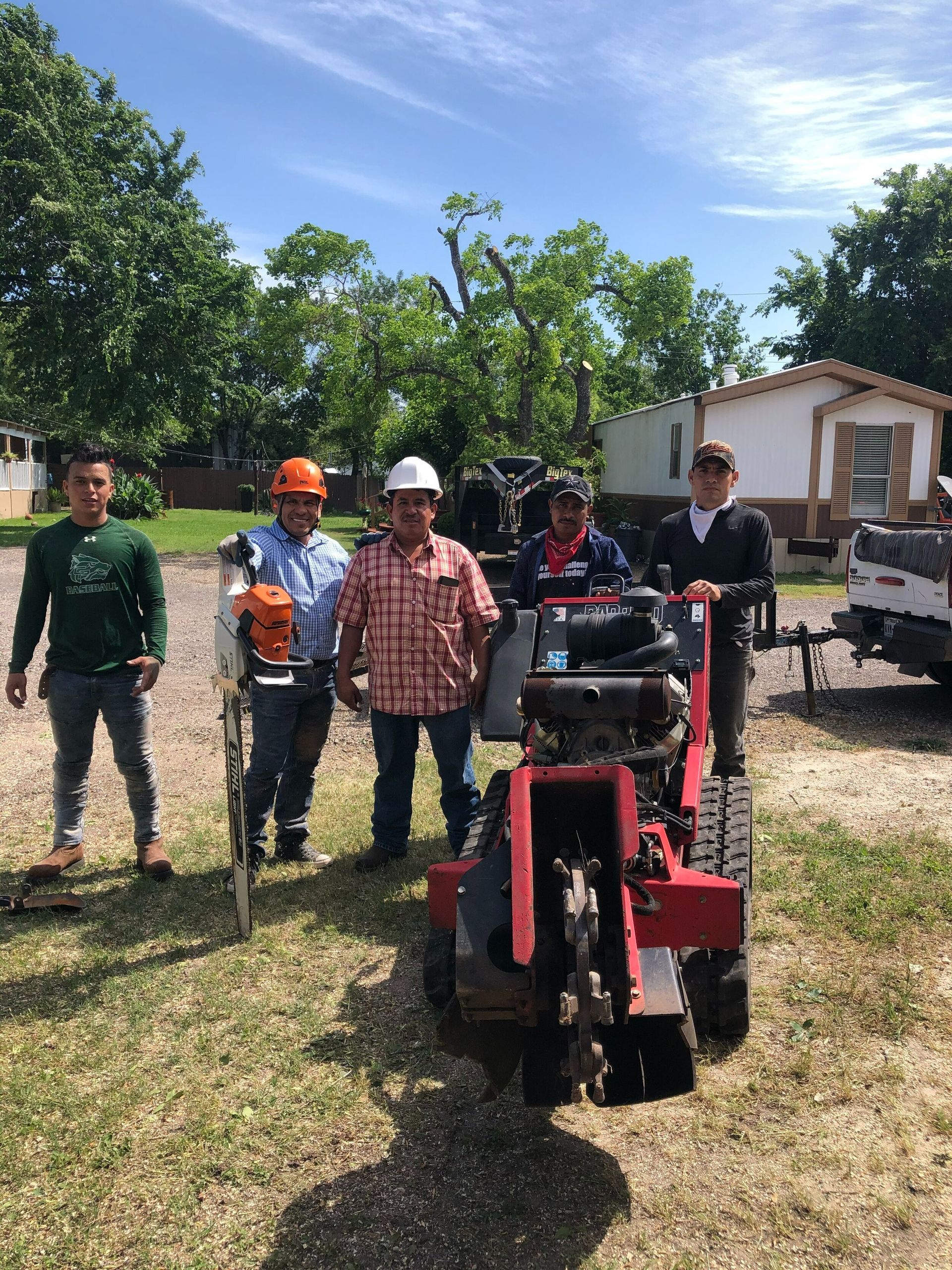 A group of men are standing in front of a tractor.
