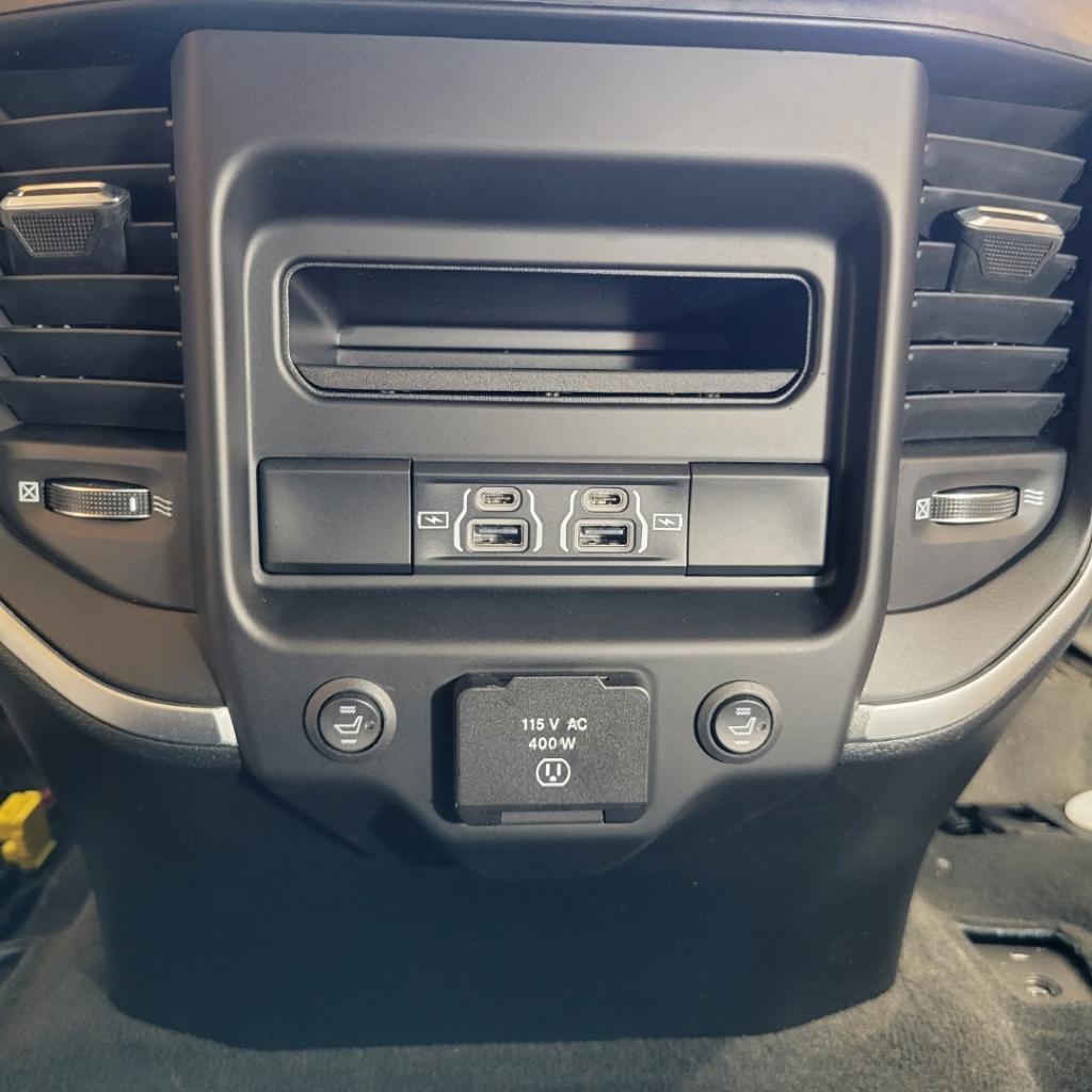 A close up of a car dashboard with buttons and a power outlet