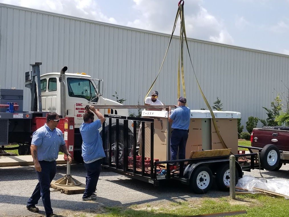 A group of men are working on a hot tub on a trailer.