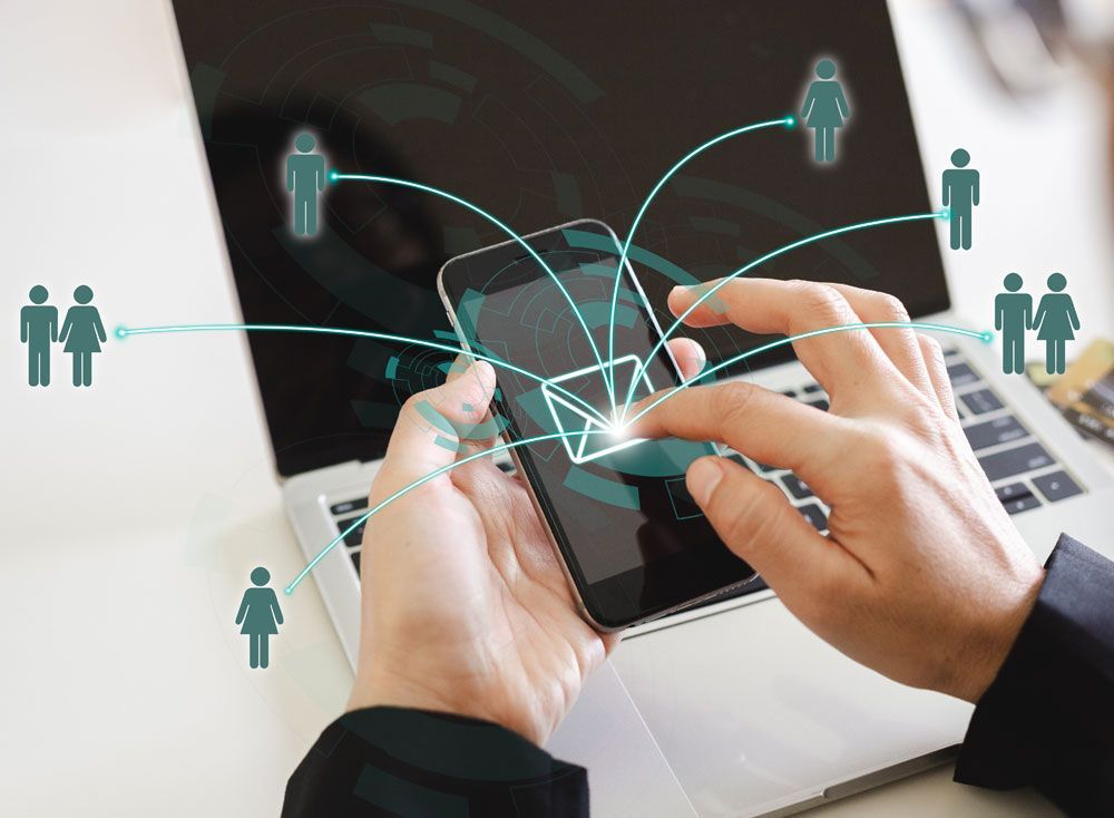 Person interacting with smartphone, connected to other people via digital network.