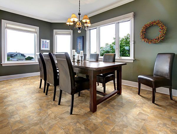 Dining room with large table, six chairs, and windows overlooking a view. Dark green walls, wood flooring.