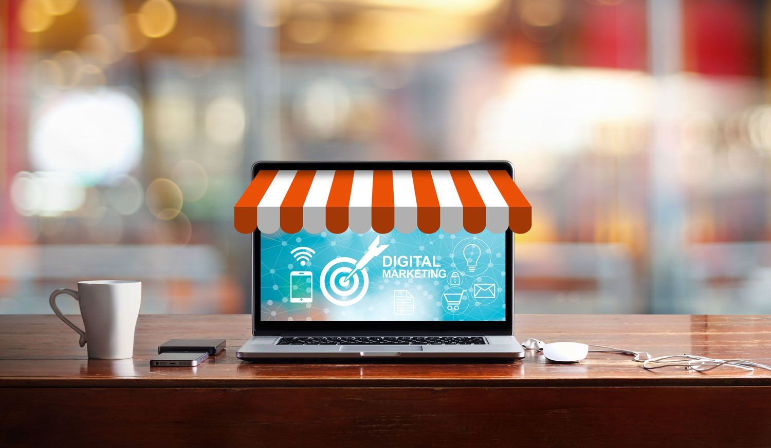 Laptop with awning graphic and coffee cup on a wooden table, suggesting an online store.