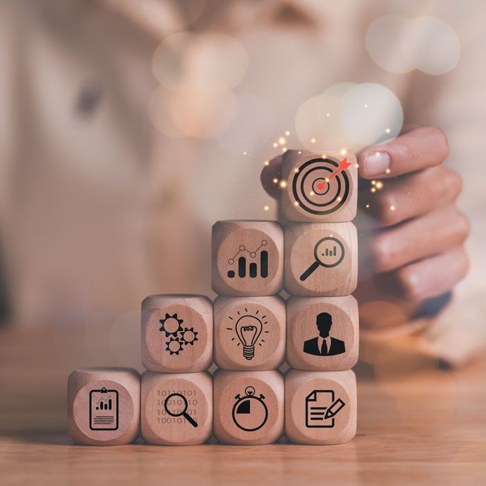 Person building steps with blocks; blocks have icons for goals, analysis, and planning.