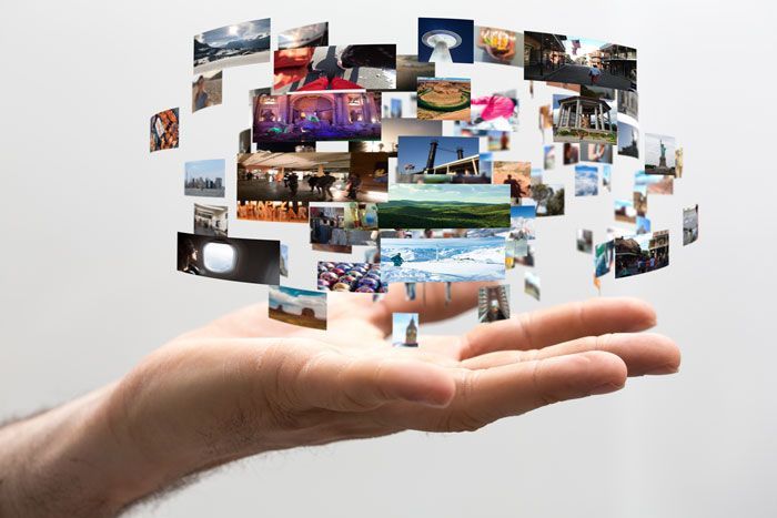 Hand outstretched, holding floating images.