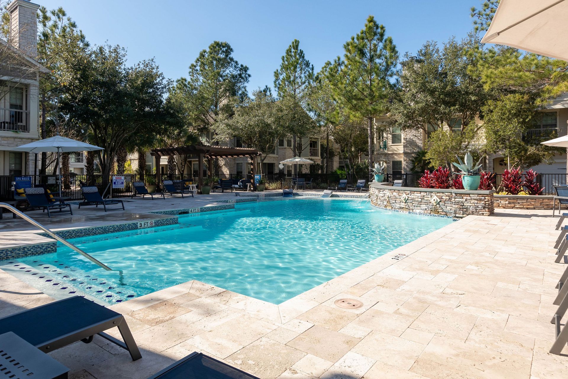 A large swimming pool with chairs and umbrellas around it