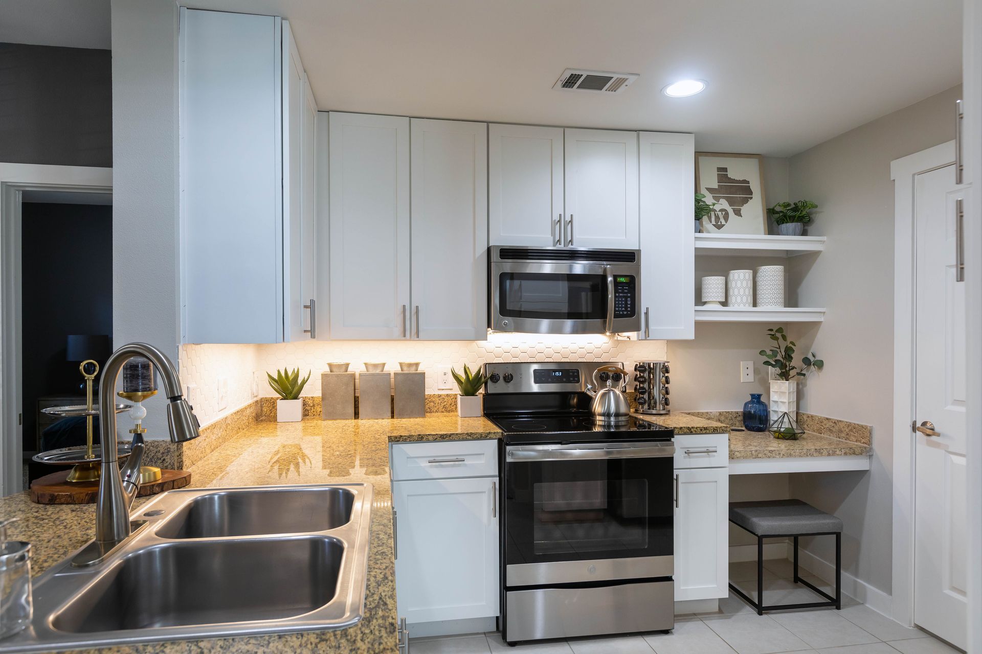 A kitchen with stainless steel appliances and white cabinets