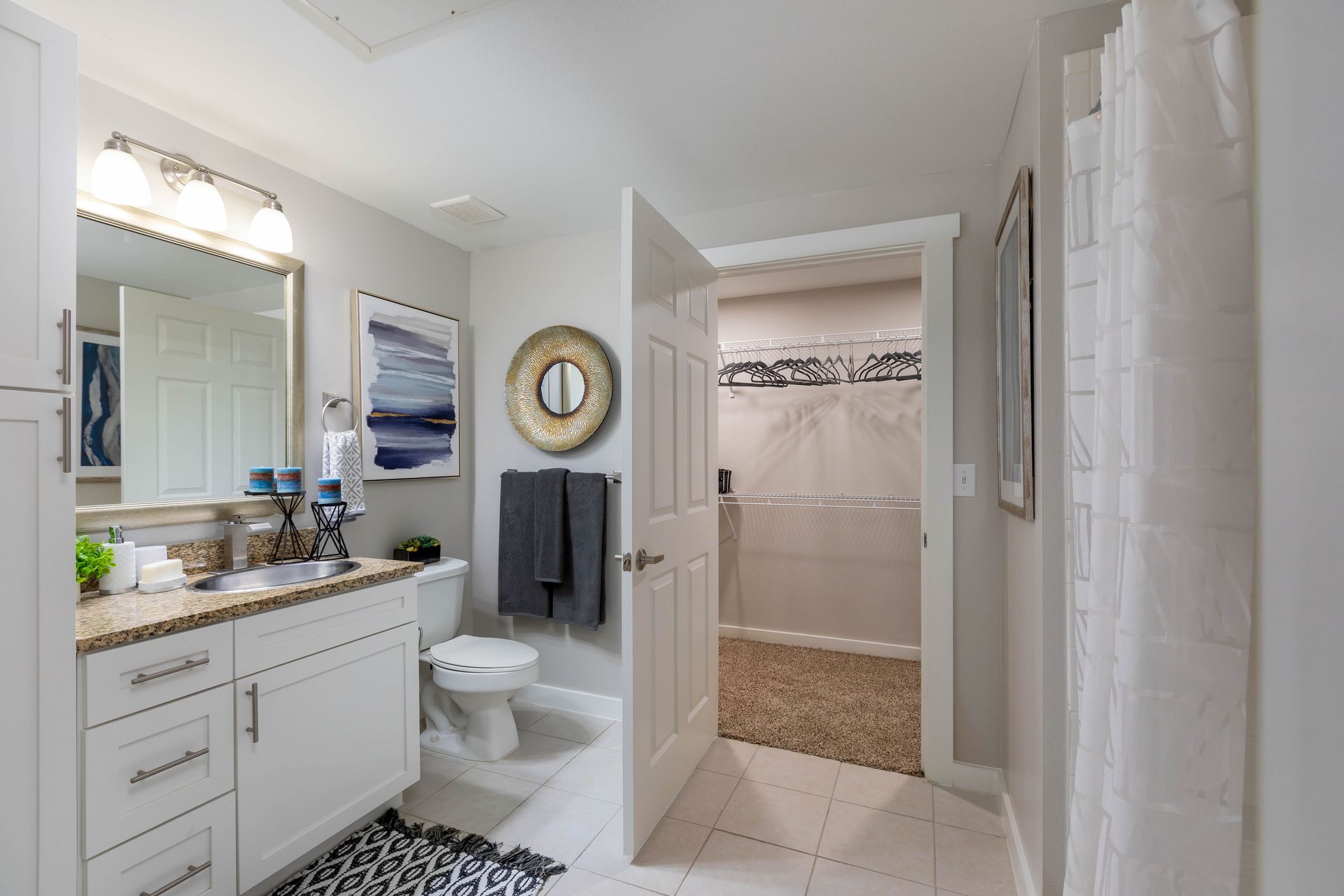 A bathroom with a toilet , sink , mirror and shower.