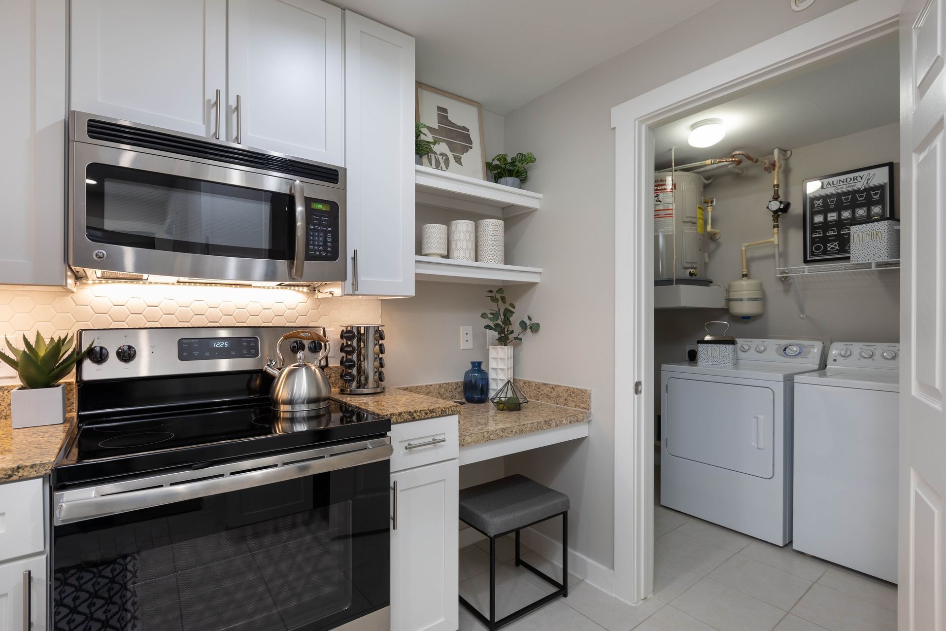A kitchen with a stove , microwave , and dryer.