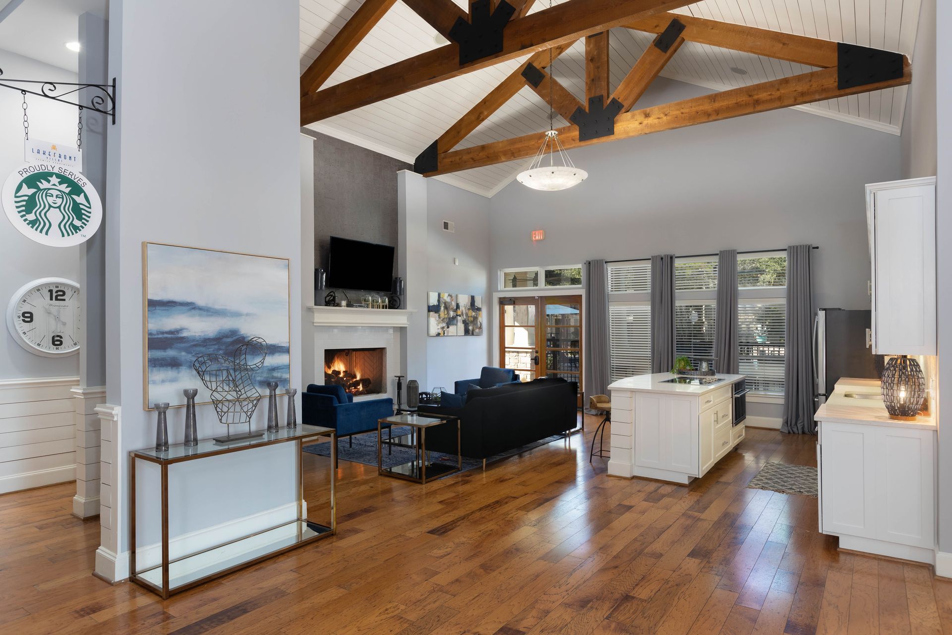 A living room with hardwood floors and a starbucks sign on the wall.