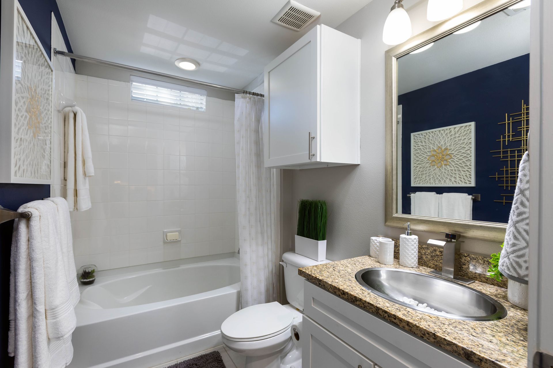 A bathroom with a sink , toilet , bathtub and mirror.